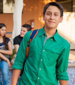 Male student wearing a backpack poses outside